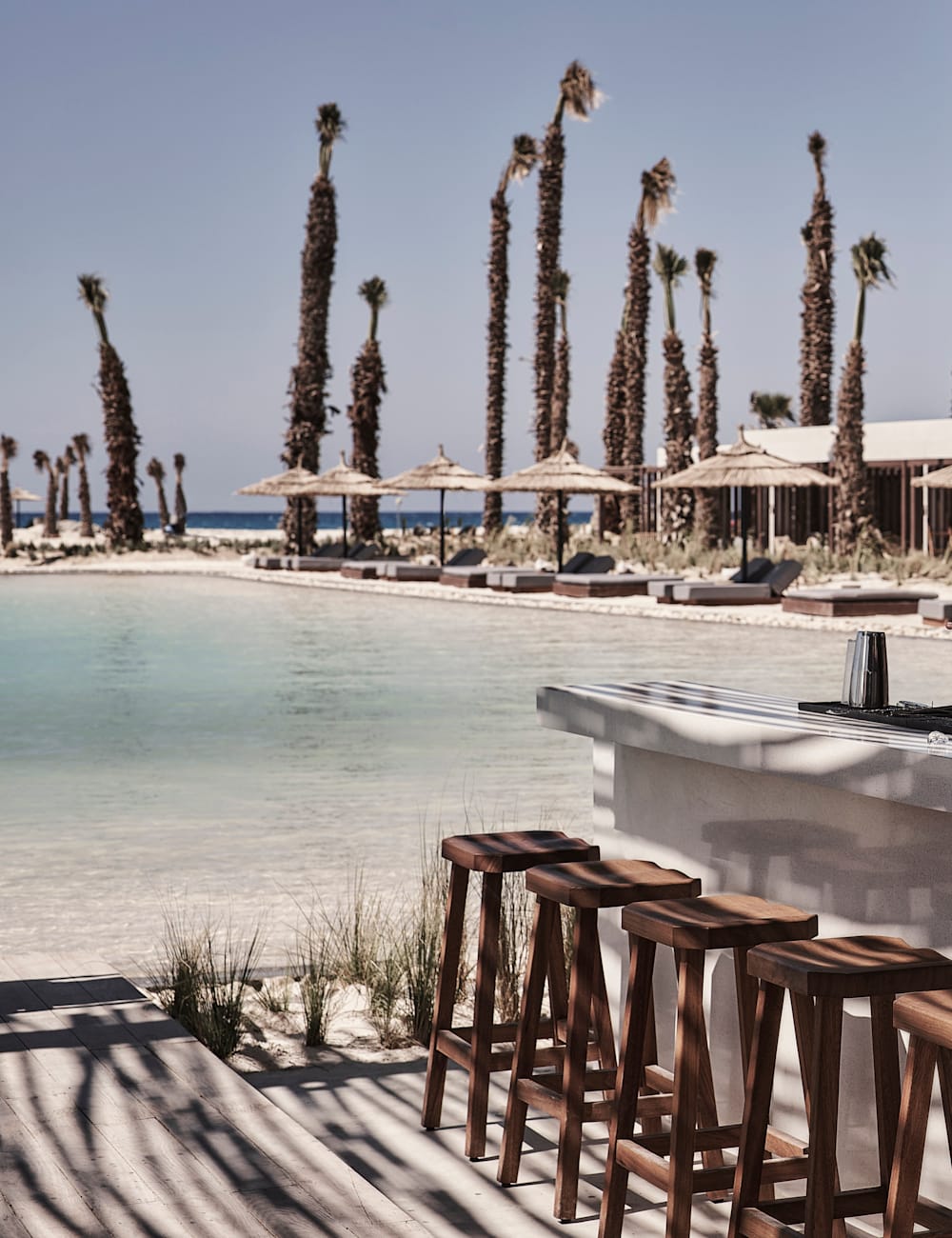 Swimming pool and bar under sun drenched blue skies