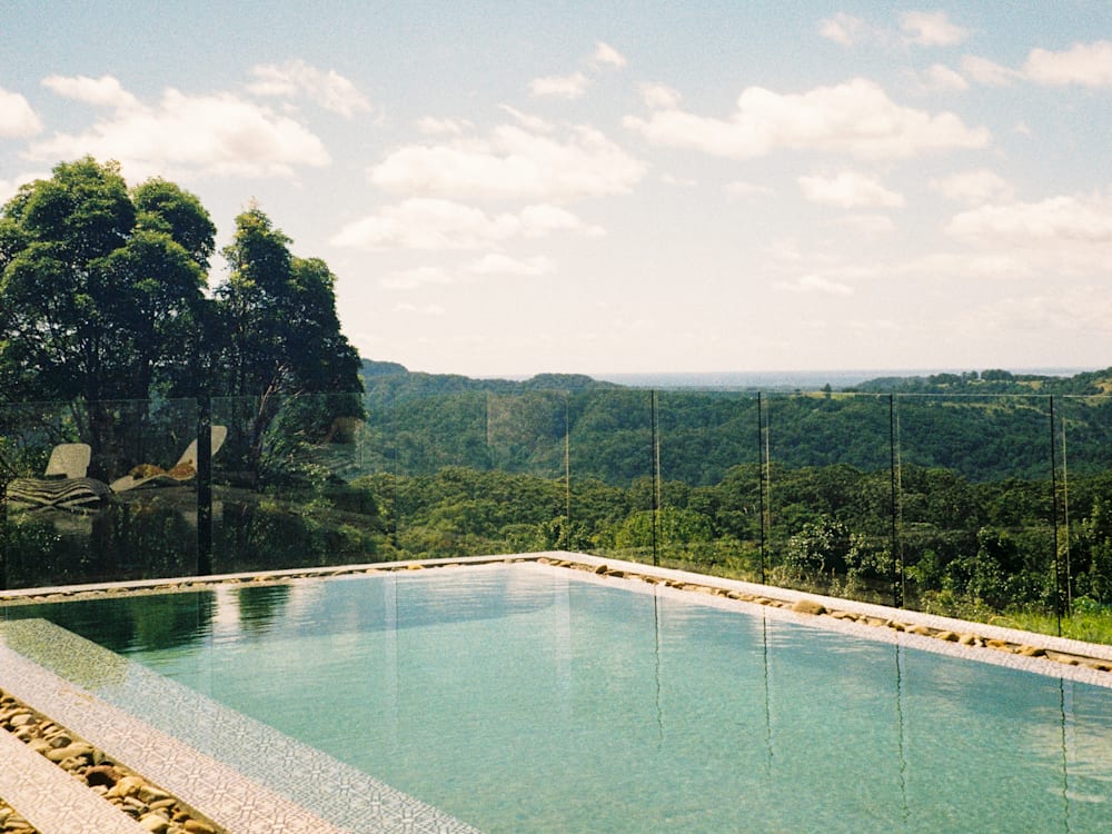 Pool and view at Blackbird Byron. Blue pool with green jungle and coastline in distance