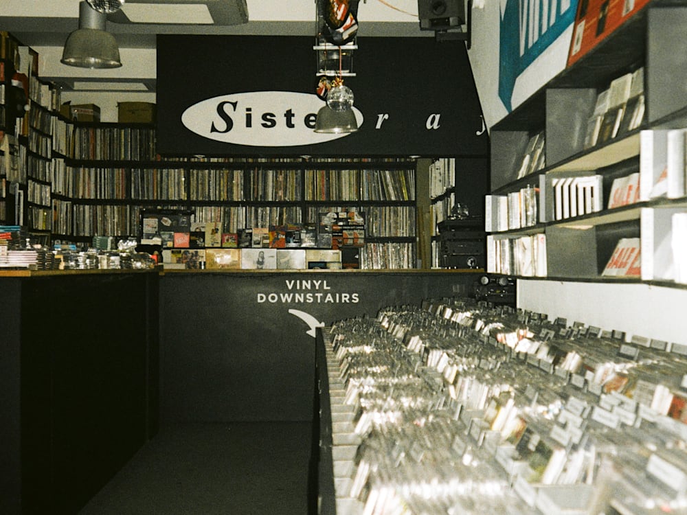 A film photo of a record store, with records lining the back of the shop and CD's running along the right hand wall.