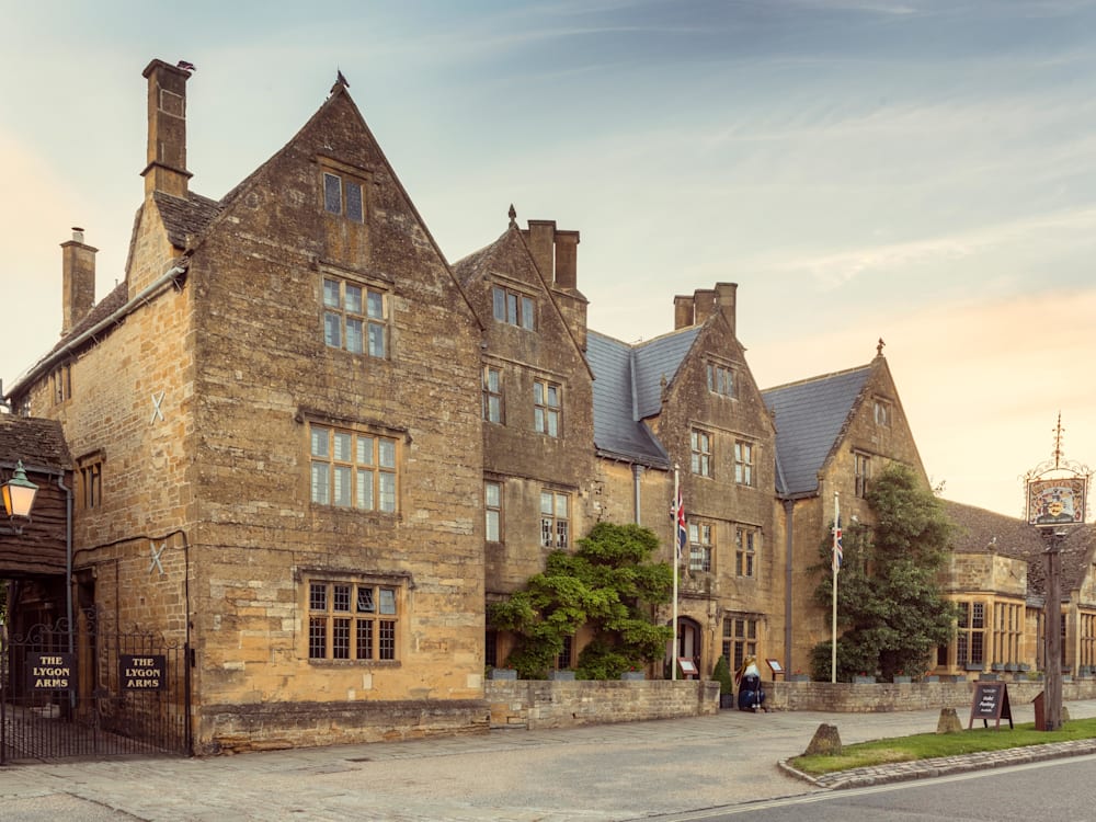 Exterior photo of the Lygon Arms building with the sun setting.