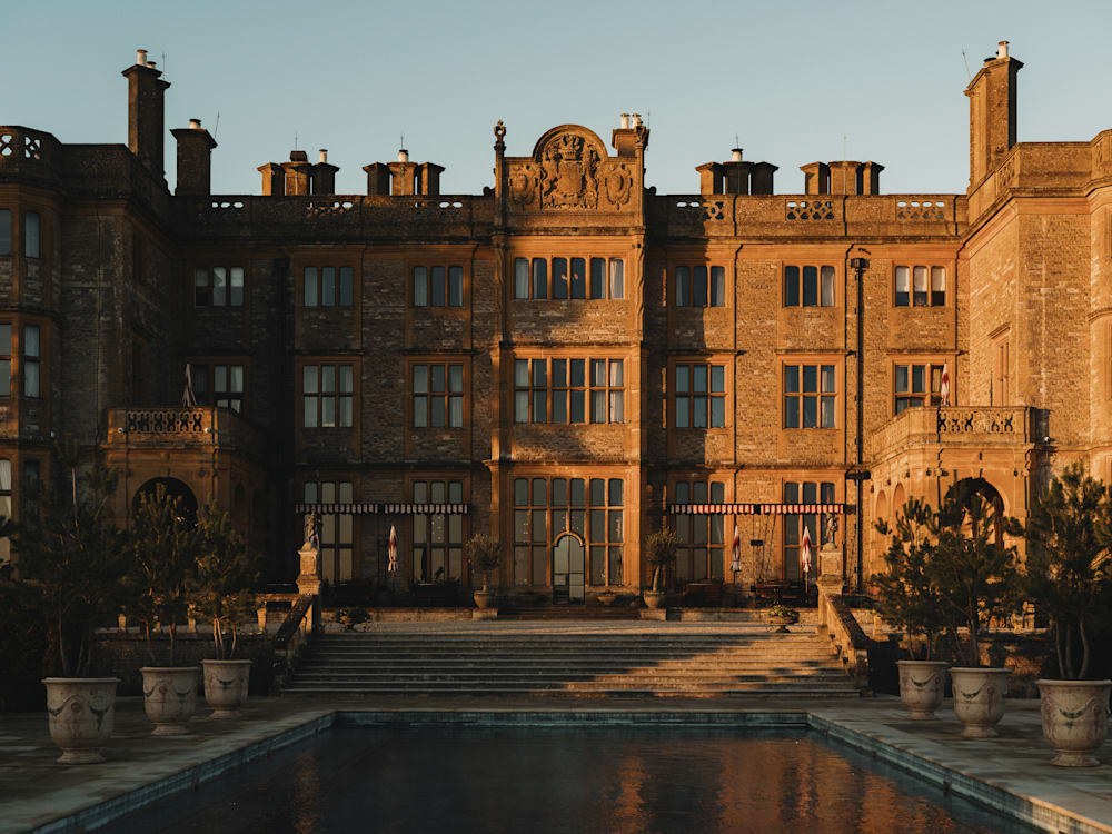 Exterior of Estelle Manor, as the sun sets casting shadows on the building and over the pool in front of the hotel.