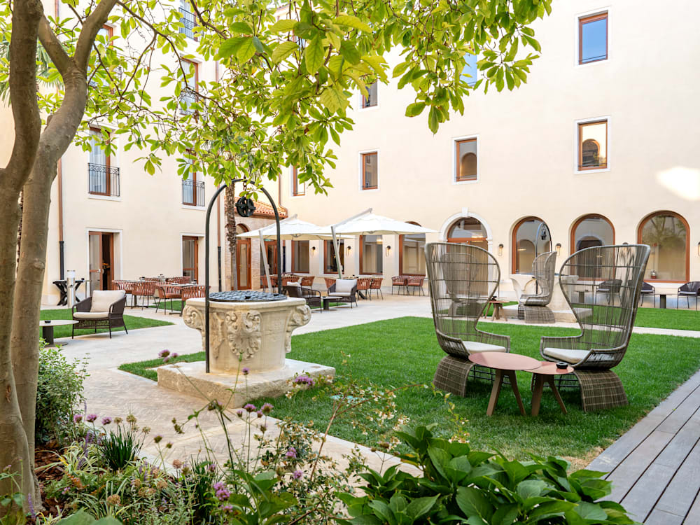 A courtyard with chairs and tables in the Ca' Di Dio hotel.